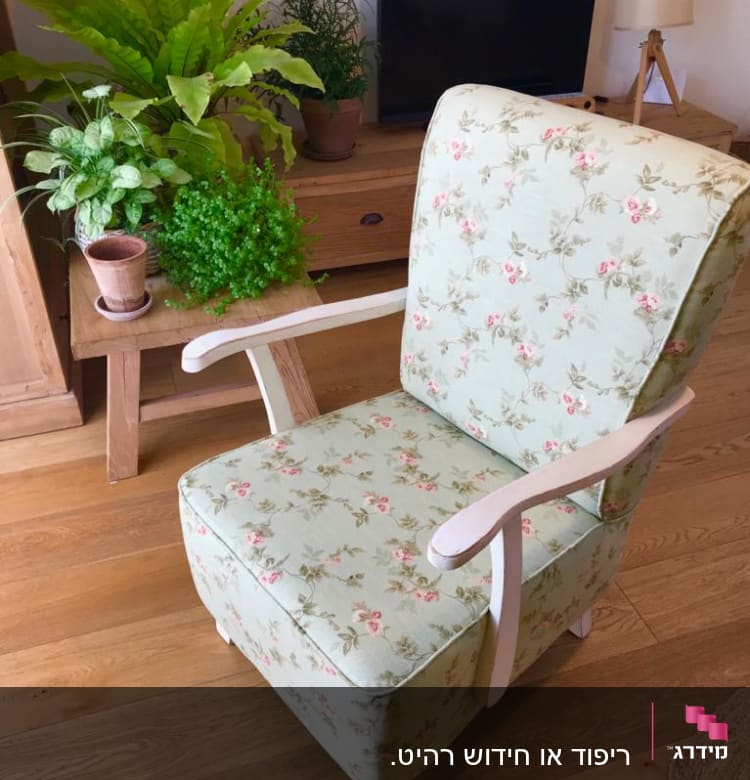 כורסה מרופדת בבד פרחוני על רצפת עץ